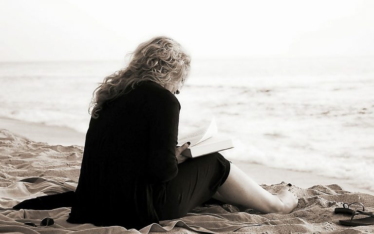 une femme qui lit un roman sur la plage